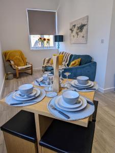 a table with plates and bowls on it in a living room at The boot factory in Leicester