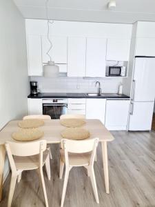 a kitchen with a table and four chairs at Villa Kaisla in Raahe