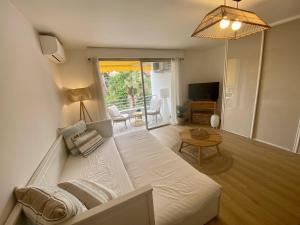 a living room with a bed and a table at Golf Juans- Studio Front de Mer, Wifi Clim in Vallauris