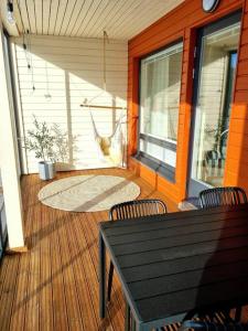 a porch with chairs and a hammock on a house at Villa Kaisla in Raahe