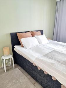a bed with white sheets and pillows in a bedroom at Villa Kaisla in Raahe