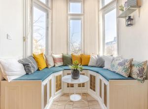 einen Fensterplatz in einem Zimmer mit Kissen und einem Tisch in der Unterkunft ClassyRooms at Rákóczi Square in Budapest