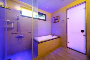 a bathroom with a tub and a shower with a glass door at 宜蘭幸福8號主題寵物友善民宿 in Wujie +42 photos