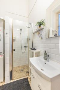 bagno bianco con lavandino e doccia di ClassyRooms at Rákóczi Square a Budapest