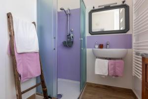 baño con paredes de color púrpura, lavabo y espejo en B&B Agriturismo La Casetta di Ben, en Viterbo