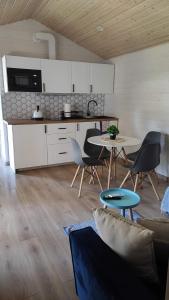 a kitchen and a living room with a table and chairs at Zakątek na Błotach in Karwieńskie Błoto Drugie