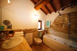 a bathroom with a sink and a tub and a toilet at Casalina B & B in Portoferraio