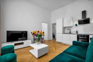 a living room with a couch and a table with flowers at Luxury Apartment next to Koszykowa Street in Warsaw