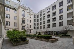 a large white building with a courtyard with plants at Luxury Apartment next to Koszykowa Street in Warsaw