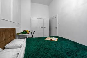 a bedroom with a green comforter on a bed at Luxury Apartment next to Koszykowa Street in Warsaw