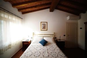 a bedroom with a bed with a blue pillow on it at Casalina B & B in Portoferraio