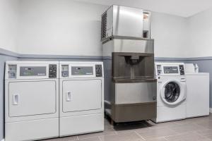 a laundry room with three machines and a washer at Quality Inn Gainesville in Gainesville