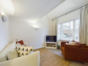 uma sala de estar com um sofá e uma televisão em “The Sleepers Cottage” 2-6 people w/ free parking em Hough Green