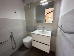 a bathroom with a sink and a toilet and a mirror at Scopello - Finestra sul cortile in Scopello +17 photos