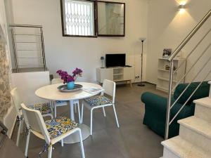 a living room with a table and chairs and a couch at Scopello - Finestra sul cortile in Scopello