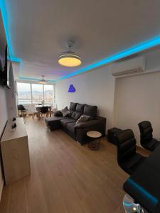 贝尼多姆Hany apartment Tropic mar 18-C的客厅里有一张黑色沙发和一张桌子