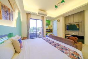 a bedroom with a large white bed and a couch at 宜蘭幸福8號主題寵物友善民宿 in Wujie