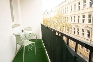 een balkon met 2 stoelen en een tafel op een gebouw bij Cozy City Apartments in center K19 in Wenen