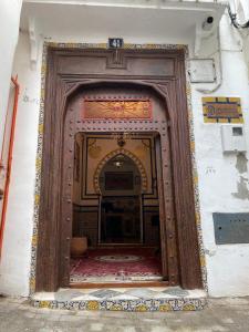 een grote houten deur in een gebouw met een kamer bij Dar Mora in Tanger