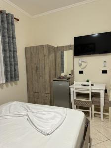 Cet appartement comprend une chambre avec un lit et une table ainsi qu'une cuisine. dans l'établissement VILA Eljus, à Durrës