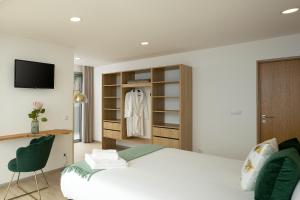 ein Schlafzimmer mit einem weißen Bett und einem Fernseher in der Unterkunft Bella Vista (Heated Pool & Private Parking) in Arco da Calheta + 28 Fotos