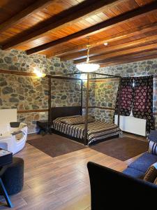 um quarto com uma cama num quarto com paredes de pedra em Gioras Hotel em Palaios Agios Athanasios