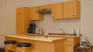 a kitchen with wooden cabinets and a counter with stools at Sylvias Ferienwohnungen Nr.1 Hochparterre in Görlitz