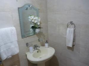 a bathroom with a sink and a mirror and white towels at Apartamento luminoso, espacioso y funcional, como en casa in El Seis
