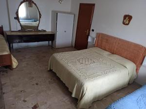 1 dormitorio con cama, espejo y piano en elyhouse, en Gizzeria