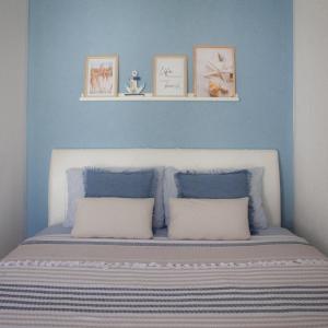 a blue bedroom with a bed with two pillows at Apartman Harmony in Sutomore