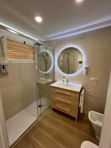 y baño con ducha, lavabo y espejo. en Hany apartment Tropic mar 18-C, en Benidorm