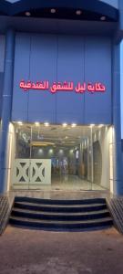 a building with a staircase in front of a store at حكاية ليل للشقق الفندقية in Hail