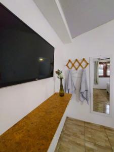 a living room with a large flat screen tv on the wall at Na Casa Delas Jeri - com Churrasqueira in Jericoacoara