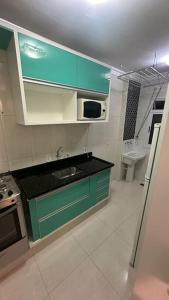 - une cuisine avec des placards verts et un évier dans l'établissement Próx Armando Panunzzio com piscina, à Sorocaba