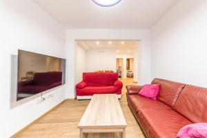 sala de estar con sofá rojo y mesa en Casa Gómez, parking gratuito en Pleno Centro, en Almería