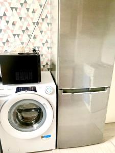 una lavadora junto a una nevera de acero inoxidable en Appartement de 3 chambres, en Ris-Orangis 10 fotos más