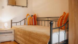 ein Schlafzimmer mit einem Bett mit orangefarbenen und orangefarbenen Kissen in der Unterkunft Sylvias Ferienwohnung Nr2 in Görlitz