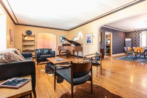 A Spacious Sanctuary for Unforgettable Group Stays في Olivette: غرفة معيشة فيها بيانو وأثاث