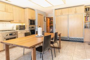 a kitchen with a wooden table and chairs at A Spacious Sanctuary for Unforgettable Group Stays in Olivette