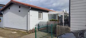 a white house with a fence in front of it at Maas Chalet Aldeneik in Maaseik