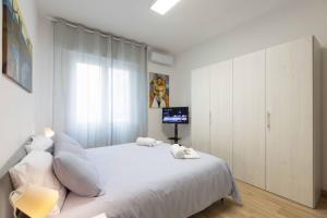 La Maison Des Artistes في كاتانيا: غرفة نوم بيضاء مع سرير أبيض وتلفزيون