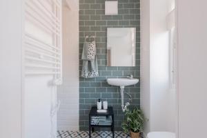 a bathroom with green subway tile and a sink at Brand new stylish ,spacious and cosy room with en suite bathroom in Madrid