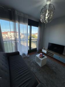 a living room with a couch and a flat screen tv at La Isla in Isla de Arosa