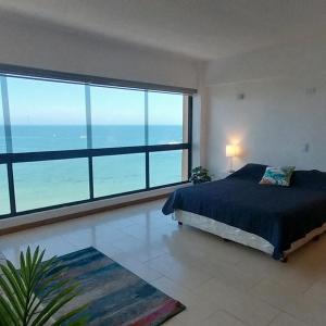 a bedroom with a bed with a view of the ocean at Apart. con aire, frente al mar in Porlamar