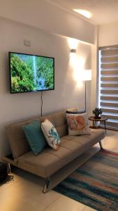 a living room with a couch and a flat screen tv at Apart. con aire, frente al mar in Porlamar