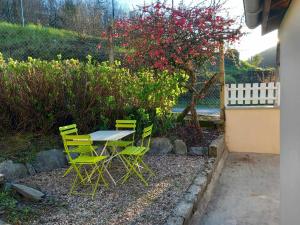 a table and chairs in a yard with a tree at Le chêne BuBu in Deville