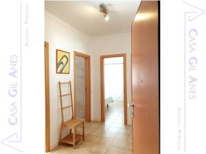 a hallway with a door and a chair in a room at Casa Gil Anes in Almada