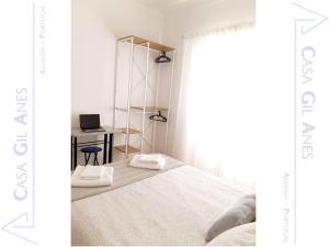 a bedroom with a bed and a desk with a laptop at Casa Gil Anes in Almada