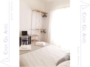 Un dormitorio con una cama y un escritorio con una computadora portátil. en Casa Gil Anes, en Almada