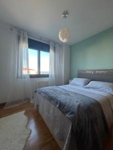 a bedroom with a large bed and a window at La Isla in Isla de Arosa
